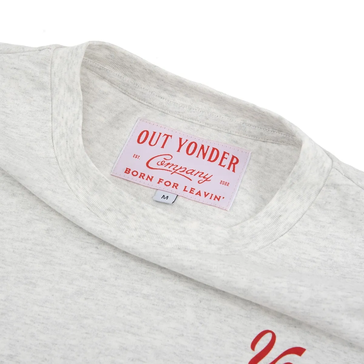 Woven Out Yonder neck label inside the collar of a heather gray T-shirt